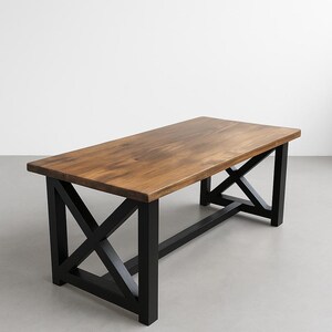 Peut inclure: Table basse rectangulaire en bois avec un plateau marron foncé et des pieds noirs en forme de X. La table mesure environ 152 cm de long, 76 cm de large et 46 cm de haut. Design rustique et moderne.