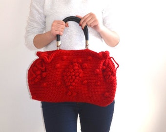 May include: A vibrant red crochet handbag with a textured design. The bag features a black handle and gold-colored hardware. The bag's dimensions are approximately 12 inches in length and 8 inches in height, offering a stylish accessory.