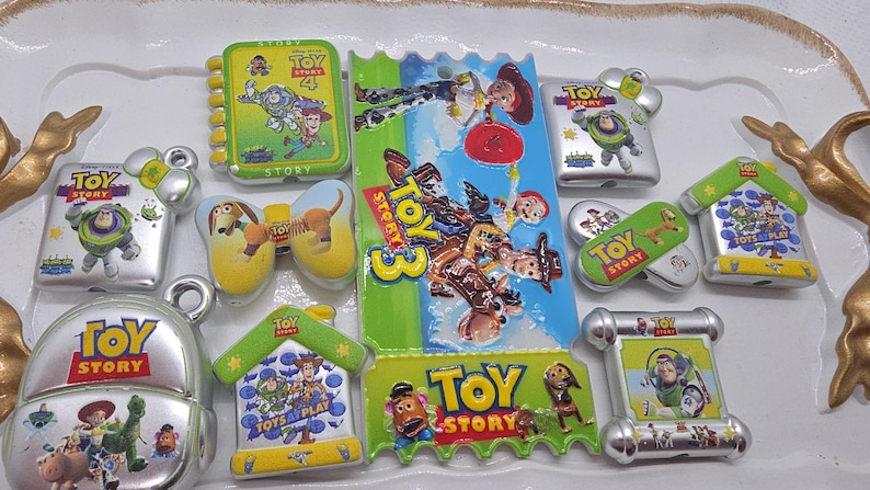 Puede incluir: Una colecci&oacute;n de imanes y amuletos con el tema de Toy Story. Los dise&ntilde;os presentan personajes como Buzz Lightyear, Woody y otros de la serie de pel&iacute;culas animadas. Los art&iacute;culos tienen varias formas, incluyendo una mochila, casas y libros.