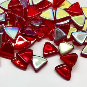 May include: A collection of triangular glass mosaic tiles in shades of red, silver, and yellow. The tiles have a glossy finish and are scattered on a white surface. These decorative tiles are suitable for various craft projects.