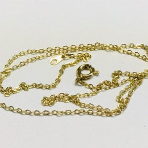 May include: A gold chain necklace with a lobster clasp closure.