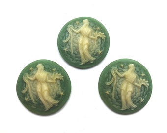 May include: Three round green and white cameo buttons with a raised design of a woman in a flowing robe holding a branch and a ribbon. The buttons have a star-like pattern around the woman.