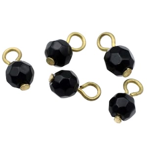May include: Six black faceted glass beads with gold-toned metal loops. The beads are approximately 1/2 inch in diameter.