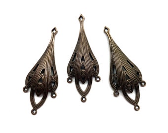 May include: Three antique gold-toned metal pendant charms with intricate filigree designs. Each charm features a teardrop shape with a pointed top and three small loops at the bottom.