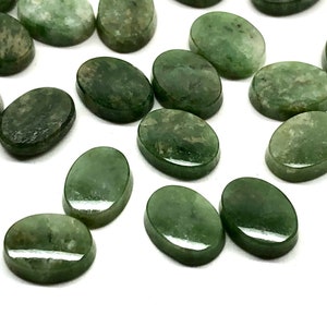 May include: A collection of oval-shaped green gemstone cabochons. The stones have a mottled green color and a smooth, polished finish.