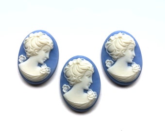 May include: Three white cameo pendants with a woman's profile in relief, set against a light blue background.