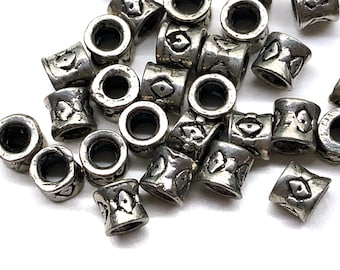 May include: A collection of silver metal beads with a decorative design. The beads have a round hole in the center and are designed to be used for jewelry making.