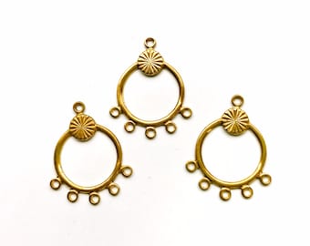 May include: Three gold-toned metal earring findings with a circular design and five jump rings. Each finding has a decorative, starburst-shaped top.