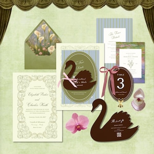 May include: A wedding stationery set featuring a cream invitation with ornate borders, a green envelope with floral lining, a blue striped card, a brown swan-shaped RSVP card, a brown oval table number card with a pink ribbon, and a ring in a box.