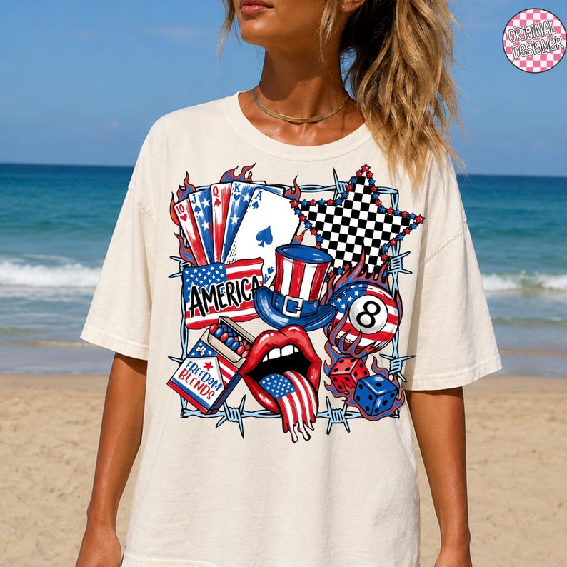 May include: Cream-colored t-shirt featuring a patriotic graphic with playing cards, an American flag, a top hat, dice, and a mouth with the American flag as the tongue. The graphic includes the word "AMERICA" and "FREEDOM BLENDS".