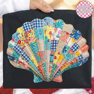 May include: A black tote bag featuring a colorful, patchwork seashell design. The seashell is made of various patterned fabrics, including floral, gingham, and nautical motifs. The design includes the text "ORIGINAL DESIGNER" in a pink circle.