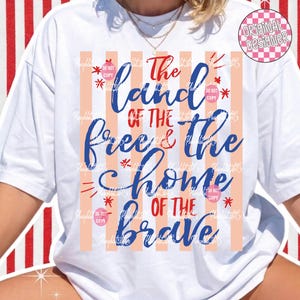 Puede incluir: Camiseta blanca con un dise&ntilde;o patri&oacute;tico. La camiseta presenta el texto "The land of the free & the home of the brave" en azul y rojo, con rayas verticales melocot&oacute;n y blancas.