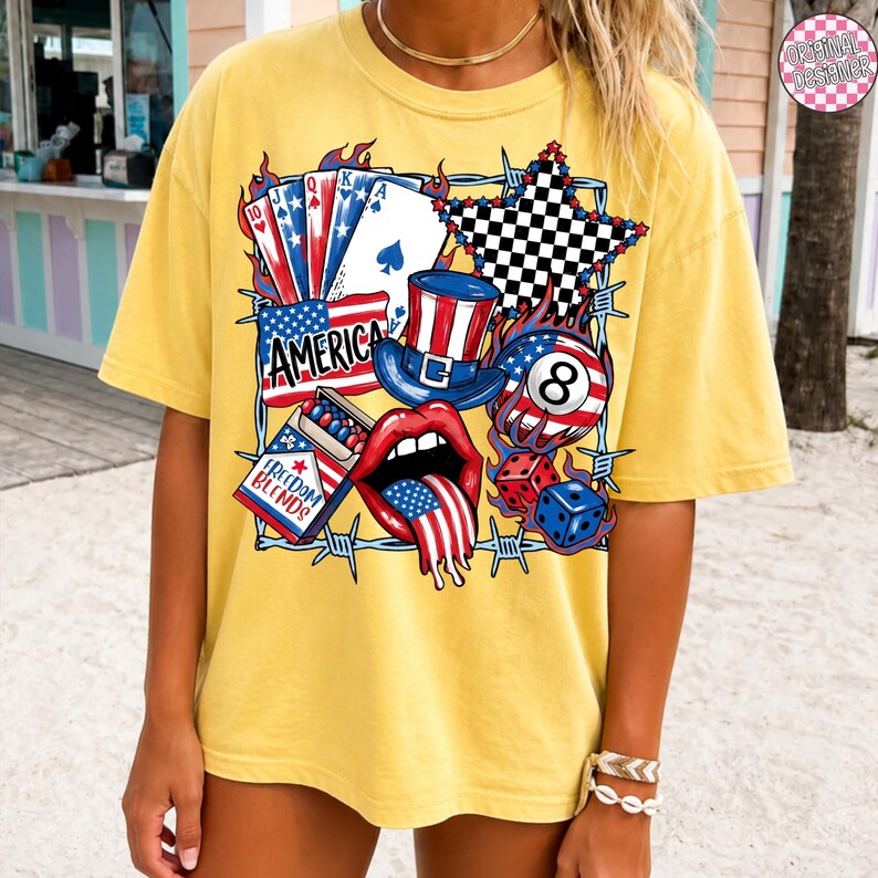May include: Yellow t-shirt with a graphic design featuring playing cards, a top hat, an 8-ball, dice, and a mouth with a tongue in the American flag design. The word "AMERICA" is also displayed.