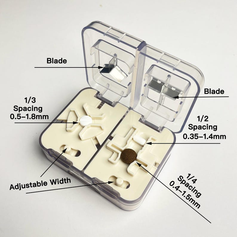May include: A clear plastic pill cutter with a beige interior. The cutter has two compartments, each with a blade and adjustable spacing for different pill sizes. The spacing options are 1/3 (0.5-1.8mm), 1/2 (0.35-1.4mm), and 1/4 (0.4-1.5mm).