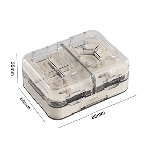 May include: A clear, rectangular pill organiser with two compartments. The organiser is 8.5 cm long, 6.4 cm wide, and 3.5 cm tall. It has a beige base and a clear lid, with measurements labeled in millimeters.