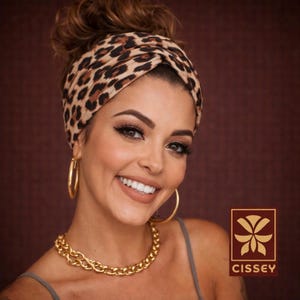 Può includere: Una donna con un turbante con stampa leopardata, orecchini a cerchio dorati e una collana a catena dorata. L'immagine presenta anche il logo del marchio "CISSEY" in un quadrato marrone e oro.