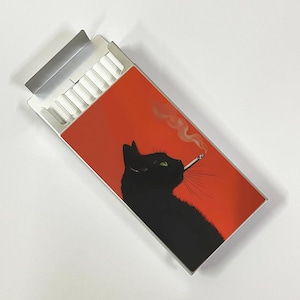 May include: A cigarette case with a red background featuring a black cat smoking a cigarette. The cat has green eyes and white smoke is coming from the cigarette. The case is open, revealing a row of cigarettes.