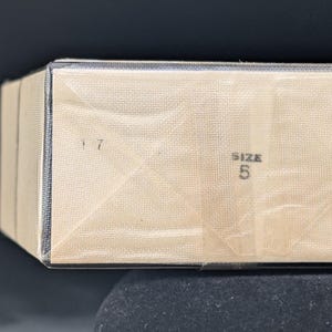 Pu&ograve; includere: Una tazza di ceramica bianca con manico nero e la scritta "But First, Coffee" in nero, con un carattere a mano. La tazza &egrave; su una superficie bianca.