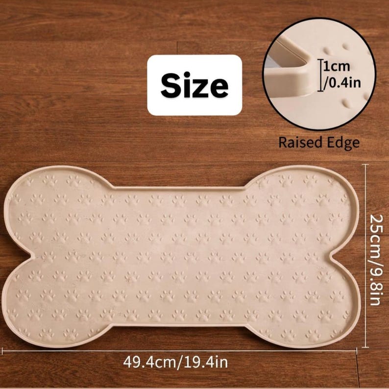 May include: A beige, bone-shaped pet food mat with paw print detailing. The mat measures 19.4 inches long and 9.8 inches wide, with a raised edge. The text "Size" is displayed on the mat.