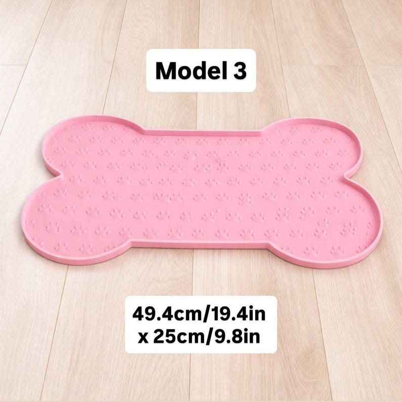 May include: Pink bone-shaped pet food mat with paw print pattern. The mat measures 19.4 inches long and 9.8 inches wide. The text "Model 3" is at the top.