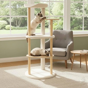 May include: A multi-level cat tree featuring light wood support posts, cream-colored circular platforms, and a central sisal-wrapped scratching post. One Siamese cat stands on the middle platform while another rests on the lower level.