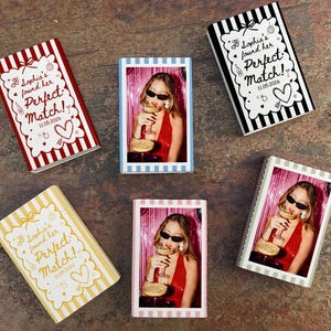 May include: A collection of personalized photo books with the text "Sophia's found her Perfect Match!" and the date 11.05.2026. The books feature a photo of a woman and are decorated with various patterns and colors, including red, white, black, and yellow.