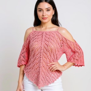 Op de afbeelding: Een roze gehaakte top met een open schouder ontwerp. De top heeft een vierkante halslijn en korte mouwen. Het haakpatroon is open en luchtig, met een geschulpte rand langs de mouwen en zoom. De top wordt gecombineerd met een witte short.
