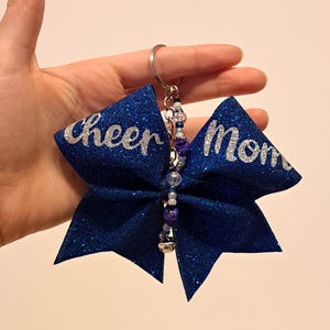 Adorno para bolso con lazo súper brillante, cuentas y diseño personalizable: el regalo perfecto para cumpleaños, Navidad o simplemente porque los quieres.