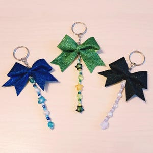 Grazioso e scintillante ciondolo per borsa con perline e fiocco completamente personalizzabile per cheerleader, ballerine o chiunque ami i ciondoli scintillanti.