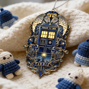 May include: A blue and gold metal TARDIS ornament with the word "TARDIS" at the base, and four small, crocheted figures in blue and white. The background is a cream-colored knitted fabric. The ornament has a silver chain for hanging.