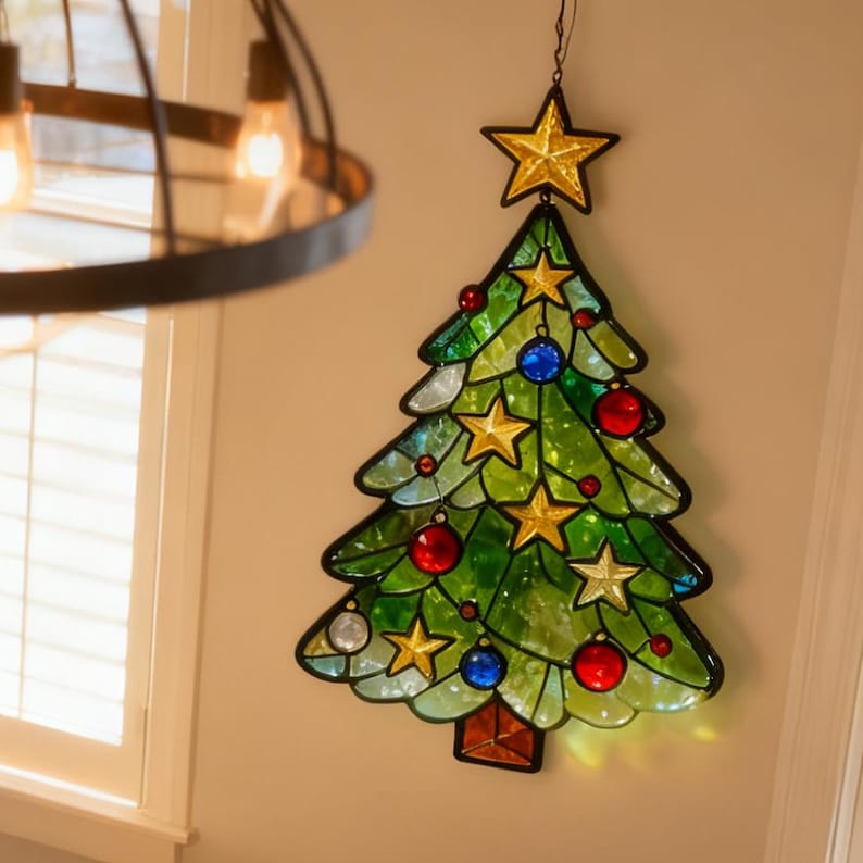 K&ouml;nnte beinhalten: Buntglas-Weihnachtsbaumdekoration mit goldenem Sternaufsatz und bunten Ornamenten. Der gr&uuml;ne Baum hat goldene Sterne und rote, blaue und silberne Kugeln. Der Baum h&auml;ngt an einer Wand.
