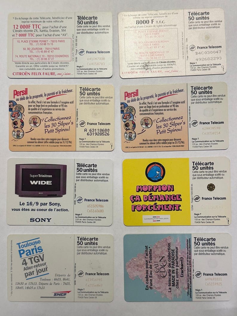 May include: A collection of vintage France Telecom phone cards, featuring various designs and text. Some cards advertise products like Citroen cars and Persil detergent. The cards are rectangular and colorful.