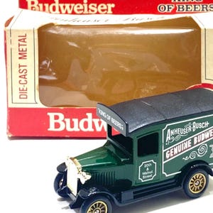 K&ouml;nnte beinhalten: Ein Spielzeug-Lieferwagen von Budweiser aus Druckgussmetall. Der gr&uuml;ne LKW hat goldfarbene R&auml;der und ein schwarzes Dach. Auf der Schachtel steht "Adult Collectable Genuine Budweiser King of Beers."