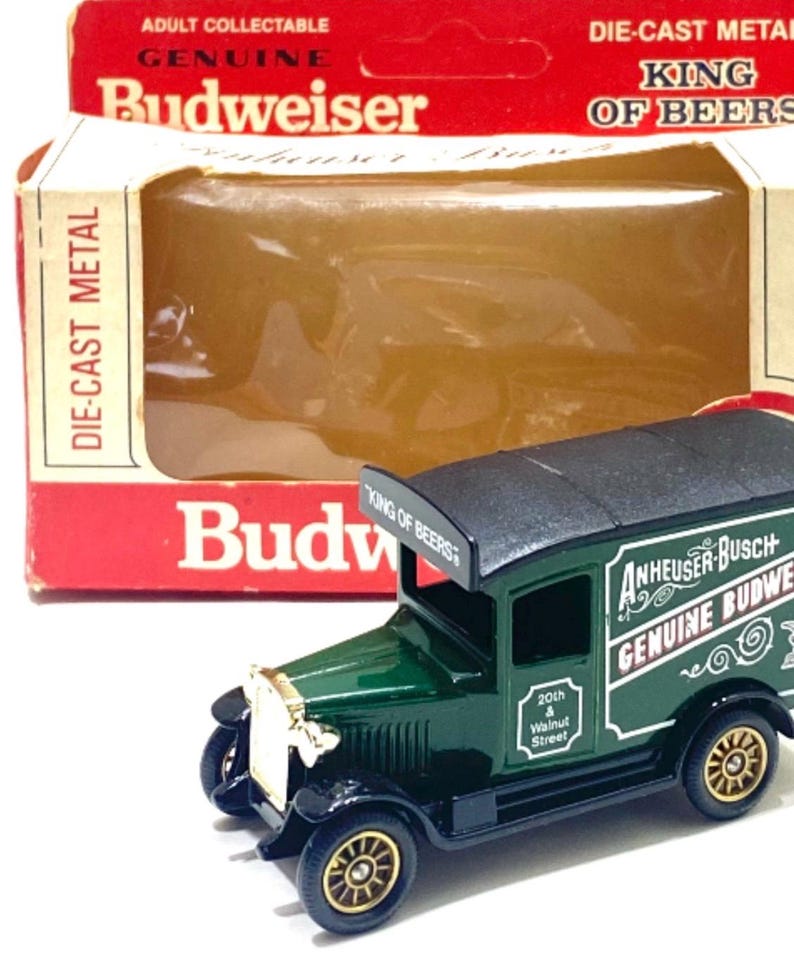 K&ouml;nnte beinhalten: Ein Spielzeug-Lieferwagen von Budweiser aus Druckgussmetall. Der gr&uuml;ne LKW hat goldfarbene R&auml;der und ein schwarzes Dach. Auf der Schachtel steht "Adult Collectable Genuine Budweiser King of Beers."