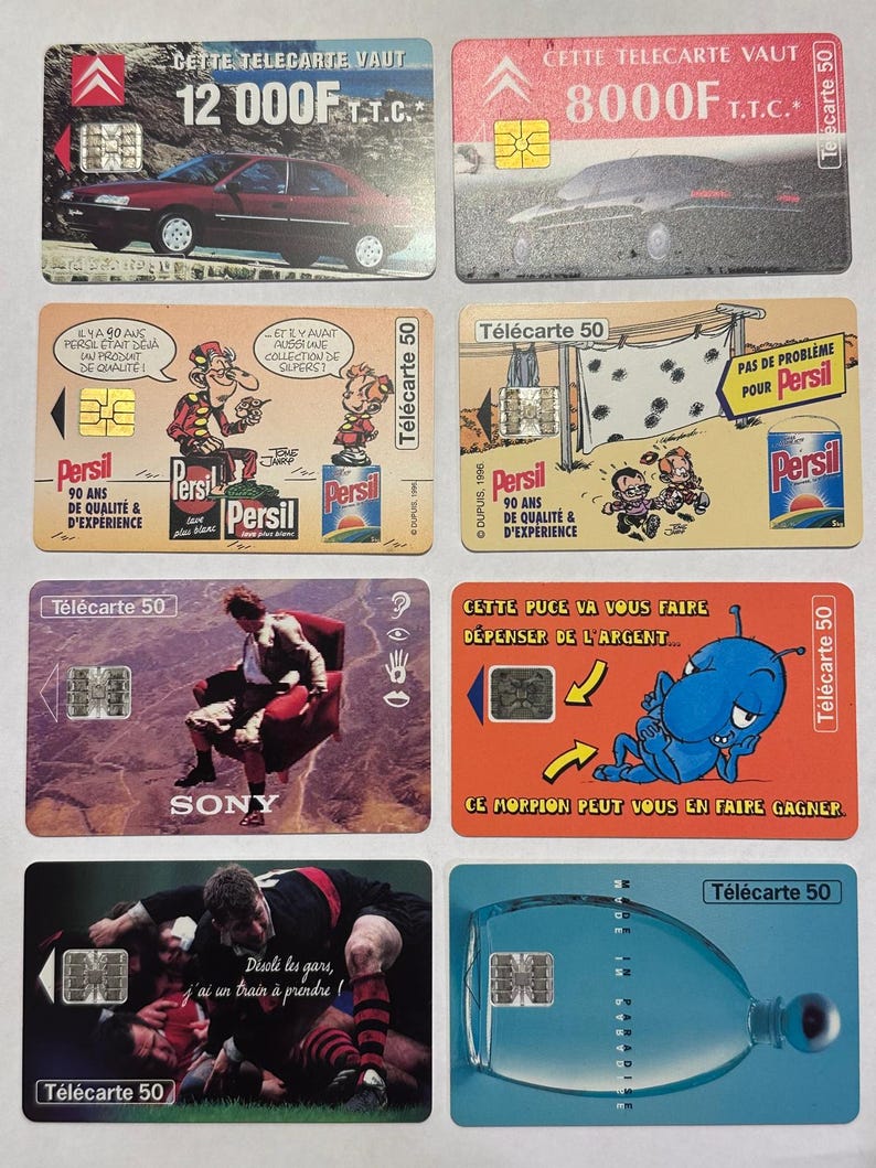 May include: A collection of vintage French T&eacute;l&eacute;carte 50 phone cards. The cards feature various designs, including cars, cartoon characters, and advertisements for Persil detergent. Some cards have the text "SONY" and "T&eacute;l&eacute;carte 50".