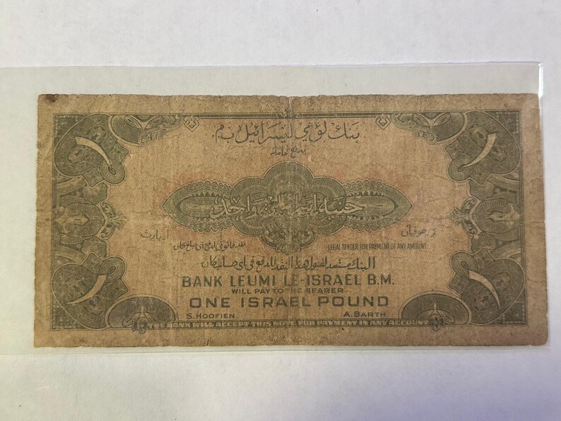 Puede incluir: Un antiguo billete de una libra israel&iacute;, con intrincadas escrituras &aacute;rabes y bordes decorativos. El billete est&aacute; impreso en tonos marrones y beige, con texto que indica que es de curso legal. El Banco Leumi Le-Israel B.M. tambi&eacute;n est&aacute; impreso.