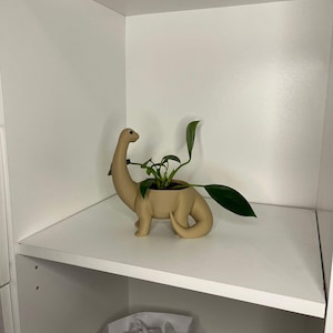 Può includere: Un set di tre tazze in ceramica con finitura opaca e macchiettata. Le tazze sono nei toni del crema, grigio chiaro e grigio scuro. Ogni tazza ha un design semplice e minimalista.