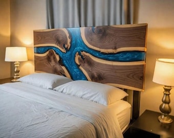 May include: A handcrafted wooden headboard with a blue epoxy resin river design. The headboard is made of dark brown wood with a glossy finish, and is set above a bed with white bedding. The room has two lamps.