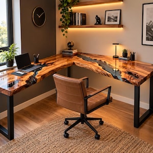 May include: An L-shaped desk featuring a natural wood slab surface with a dark resin river inlay and black metal legs. A brown leather office chair with wheels is positioned in front of the desk, which holds a laptop, pens, and a small plant.