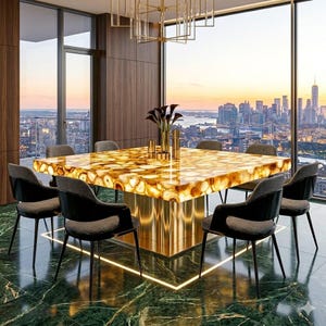 May include: A modern dining set with a large square table, featuring a golden agate-like surface. Six black chairs with grey cushions surround the table. The room has a city skyline view and a contemporary chandelier. The table is approximately 150 cm x 150 cm.