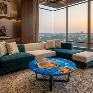 May include: A modern living room with a teal sectional sofa, beige cushions, and a round coffee table. The coffee table has a blue epoxy resin top with wooden accents. The room has large windows with a view of a cityscape.