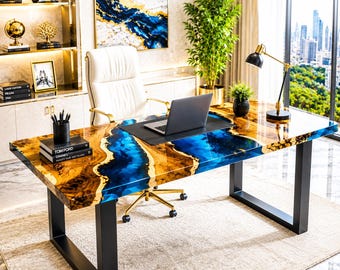 May include: A rectangular desk featuring a live-edge wood slab with a central blue resin river inlay, supported by two black metal U-shaped legs. The surface is polished and glossy, holding a laptop on a black mat, a pen holder, and books.
