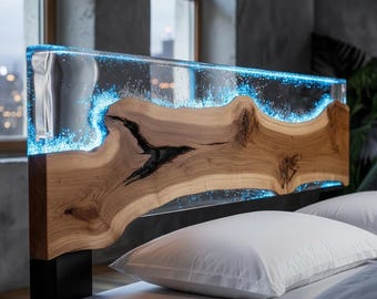 May include: A modern bed headboard featuring a live edge wood design with a clear resin top. The resin is illuminated with blue LED lights, creating a unique and stylish look. The headboard is supported by black metal legs.