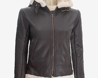 Puede incluir: Chaqueta de cuero marrón oscuro con forro y capucha de borrego color crema. La chaqueta tiene cremallera frontal, bolsillos y ribete de borrego en los puños y el dobladillo. La capucha tiene correas ajustables.