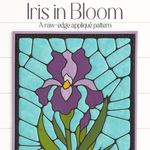 May include: A framed raw-edge appliqué pattern titled "Iris in Bloom." The artwork depicts a stylised iris flower in shades of purple, green, and yellow against a turquoise background, framed in black and lavender. The text "Iris in Bloom" is at the top.