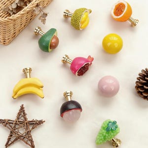 May include: A white ceramic mug with a black handle and the text "But First, Coffee" in a bold, black font. The mug is set against a blurred background, suggesting a cosy setting.