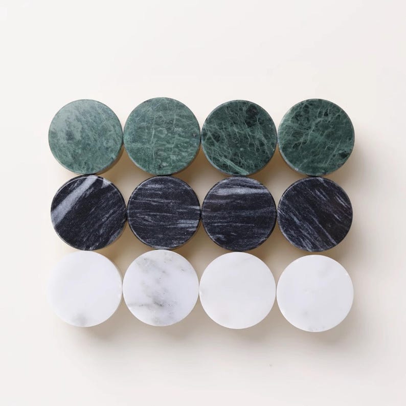 Może przedstawiać: Dwanaście okrągłych gałek do szafek z marmuru w odcieniach zieleni, czerni i bieli. Gałki ułożone są w trzech rzędach po cztery, prezentując naturalne żyłkowanie i wzory kamienia. Te dekoracyjne gałki są idealne do dodania elegancji meblom.