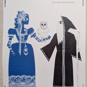 Op de afbeelding: Papieren knutselpakket getiteld "Blodeuwedd, Flower Face, A Welsh Tale". De illustratie toont een blauwe figuur met een uil en een zwarte figuur met een staf. De tekst luidt "A Cut-Out-And-Play Story."