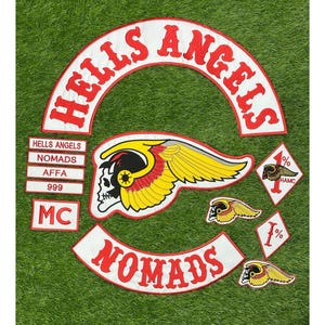 May include: A collection of embroidered patches featuring the Hells Angels logo, including a large arched top rocker with red text, a central winged skull emblem, a bottom rocker reading NOMADS, and smaller diamond-shaped 1% patches with skull icons.
