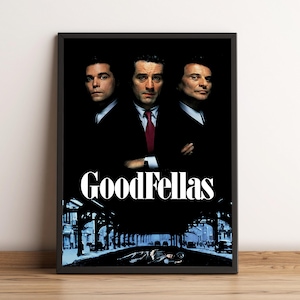 Puede incluir: Póster enmarcado de la película "Goodfellas" con tres hombres con trajes sobre un fondo negro. El título "GoodFellas" está en blanco y en negrita. La parte inferior del póster muestra una escena callejera.